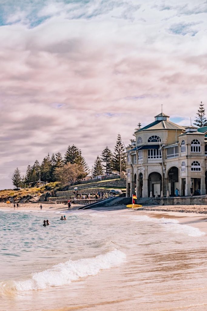 Explore the beautiful Cottesloe Beach with its iconic pavilion against a serene coastal backdrop.